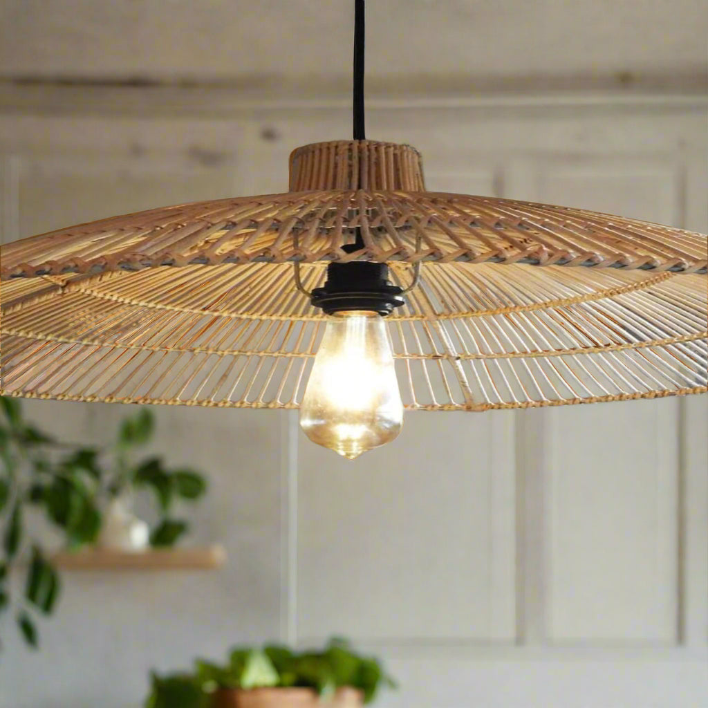 Woven pendant light with a visible bulb hanging against a neutral wall.