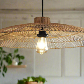 Woven pendant light with a visible bulb hanging against a neutral wall.