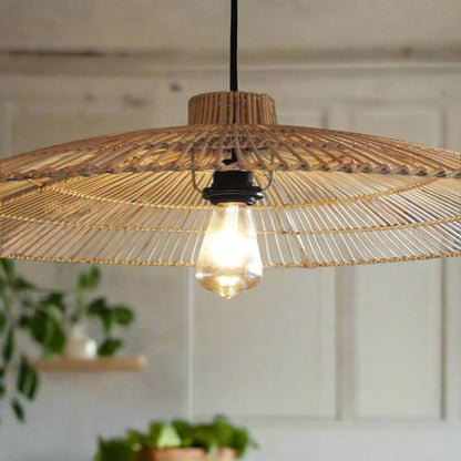 Woven pendant light with a visible bulb hanging against a neutral wall.
