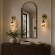 Decorative wall mirror with sconces and a cabinet in a room setting.