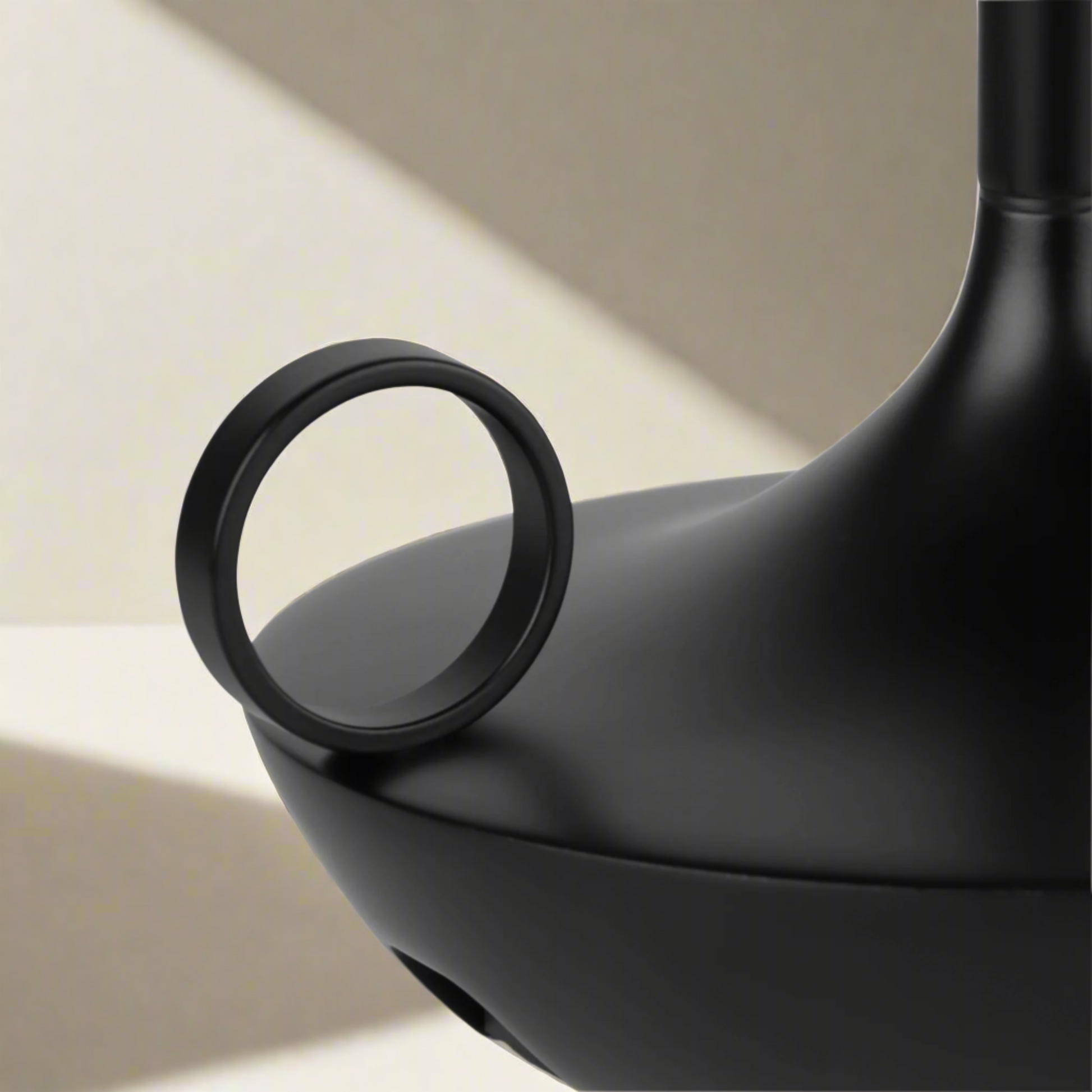 Close-up of a black teapot handle on a white background