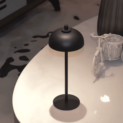 Black table lamp on a white surface with a blurred background