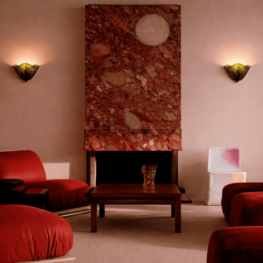 Living room with red chairs, a wooden coffee table, and a decorative wall piece.