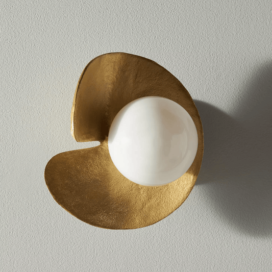 Decorative wall light fixture with gold and white design on a plain background