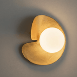 Modern wall light fixture with a warm glow on a neutral background