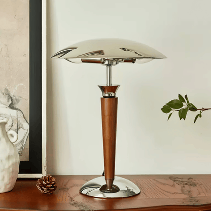 Table lamp with wooden base and glass shade on a wooden surface.