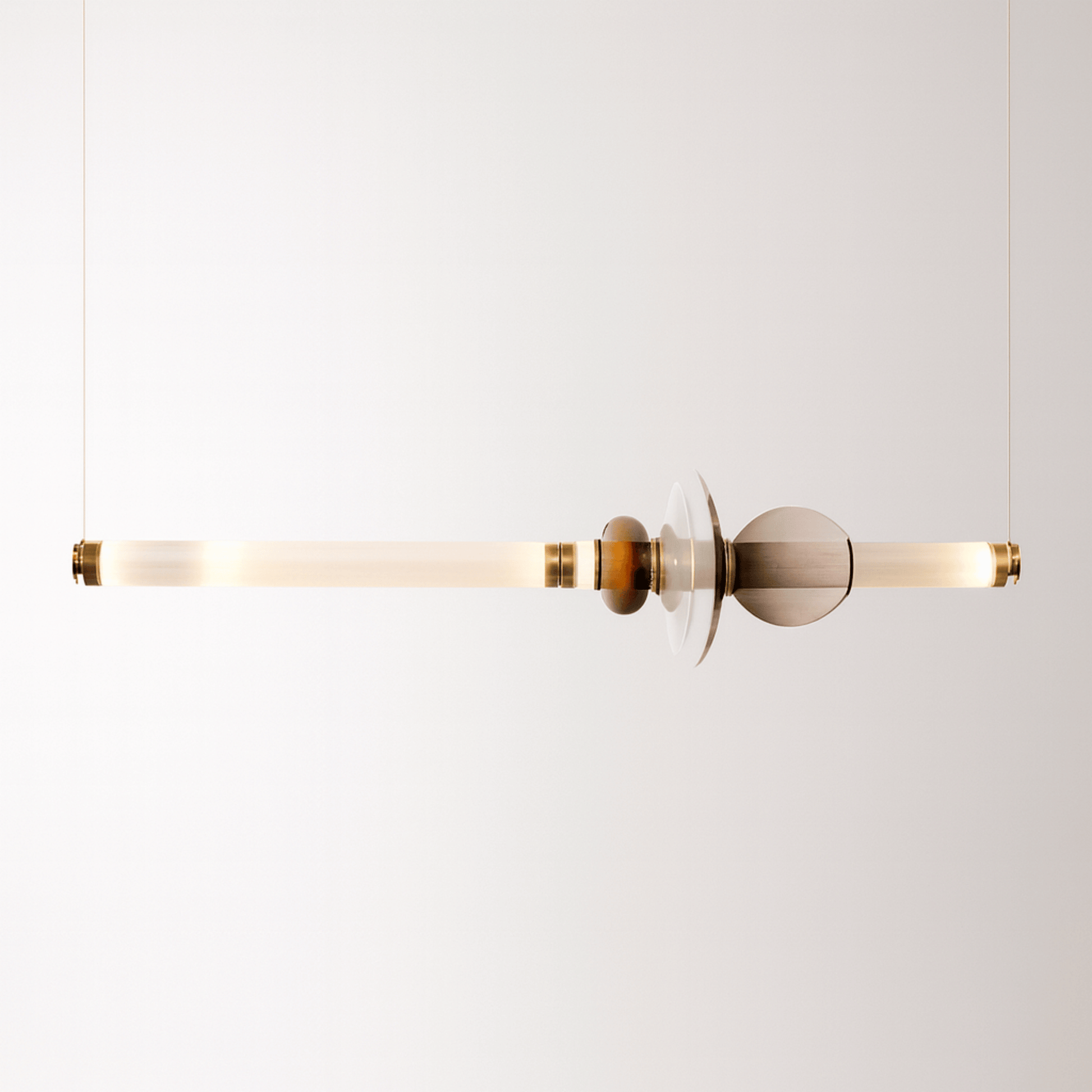 Modern pendant light with gold and glass design on a white background