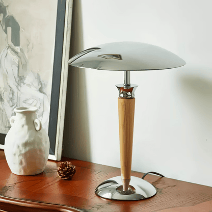 Table lamp with wooden base and white shade on a wooden surface.
