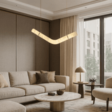 Modern living room with beige sofa, round coffee table, and pendant light.