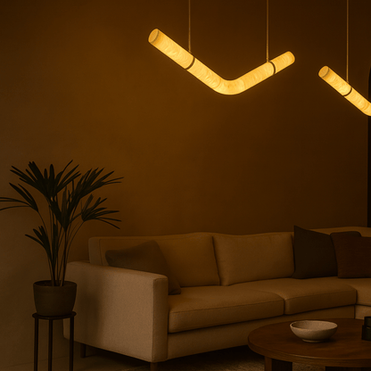 Modern living room with a beige sofa, plant, and unique pendant light fixture.