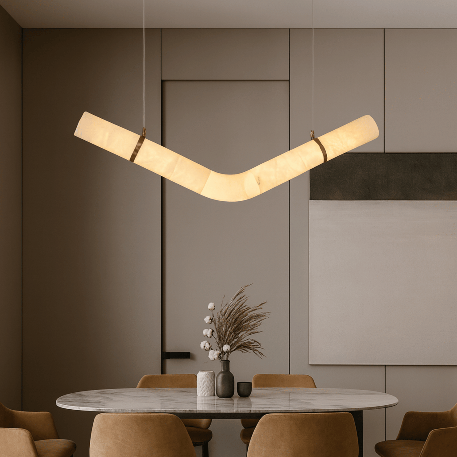 Modern pendant light hanging above a dining table with chairs in a stylish interior setting.
