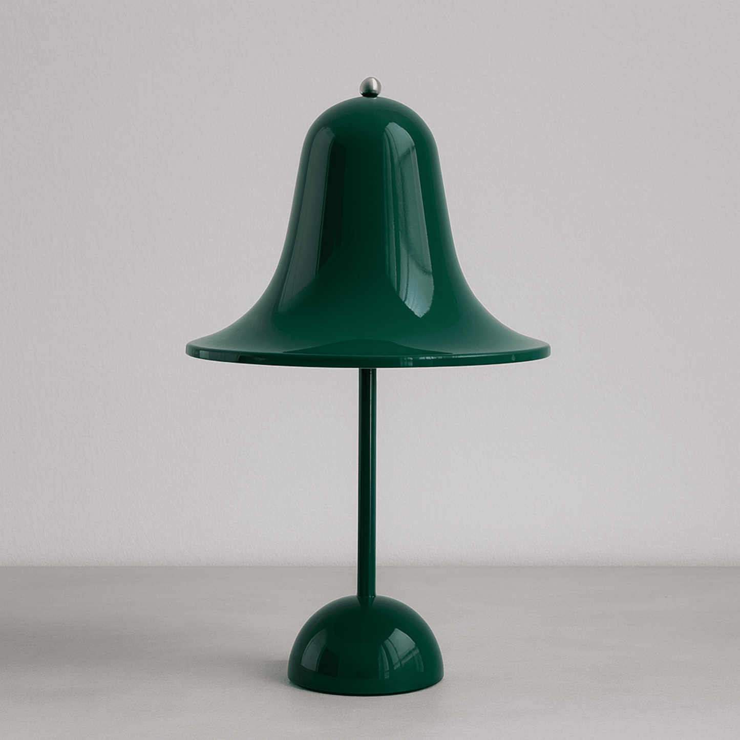 Green table lamp with a bell-shaped shade on a plain background