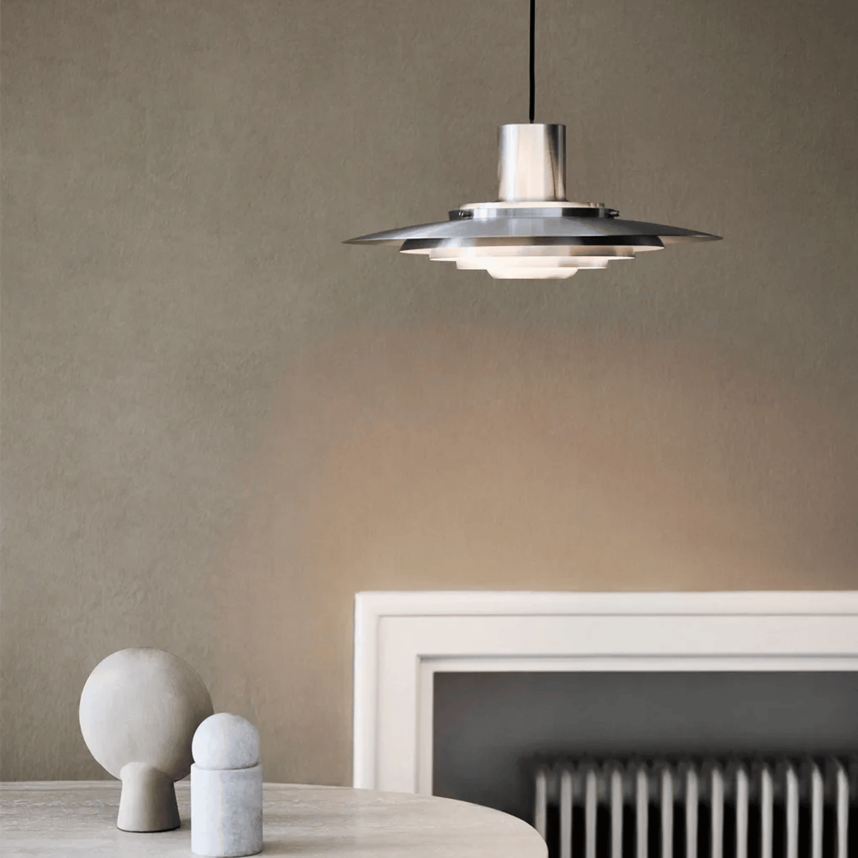 Modern pendant light fixture in a minimalistic room with a neutral color palette.