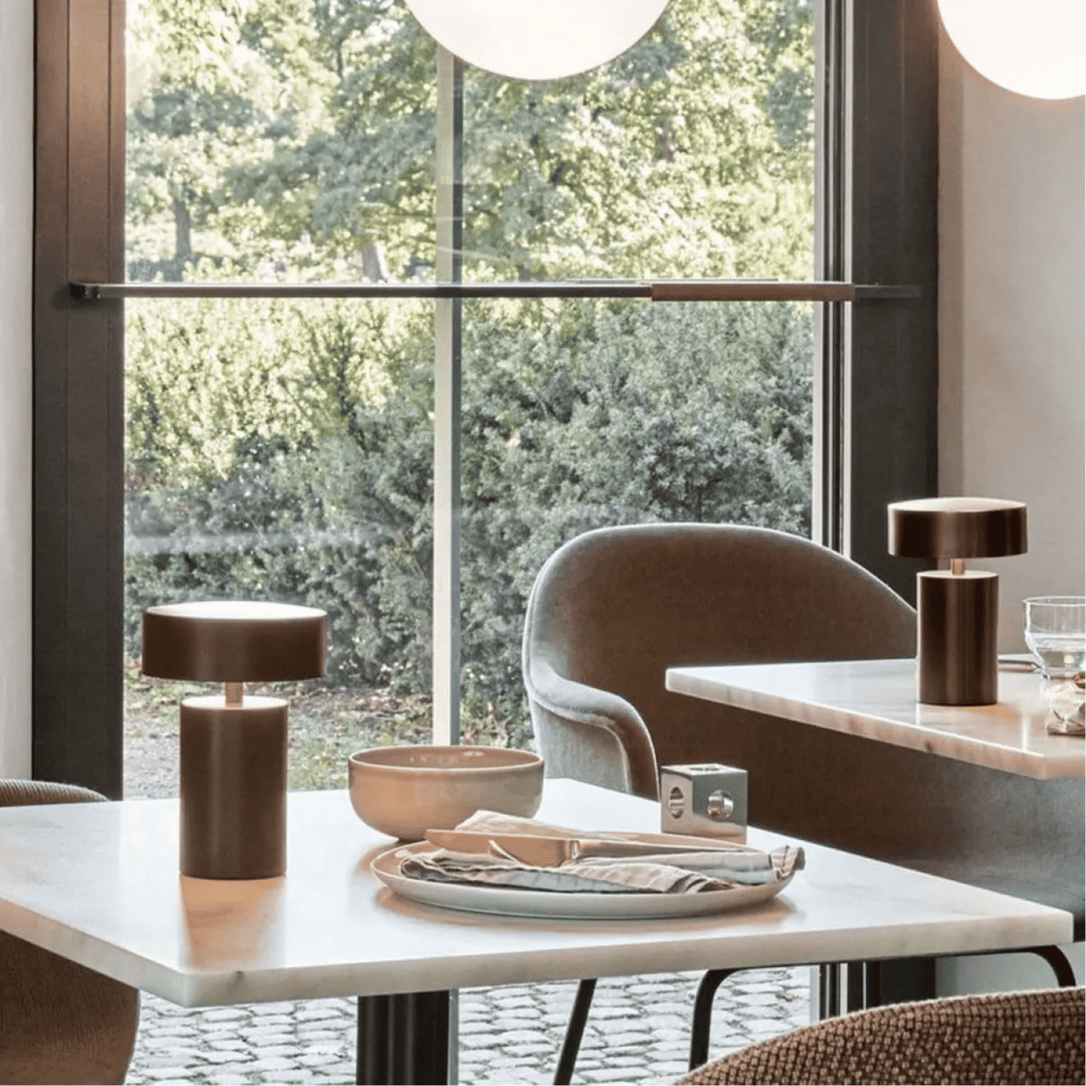 Modern dining room with marble table, chairs, and decorative items.