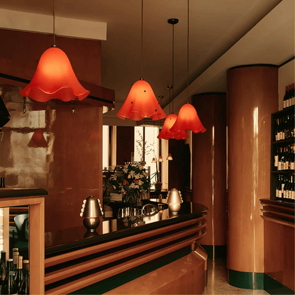 Bar area with red pendant lights, floral arrangement, and bottles.
