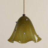Green glass pendant light with decorative beads on a beige background