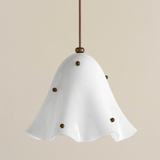White pendant light with brass accents on a beige background