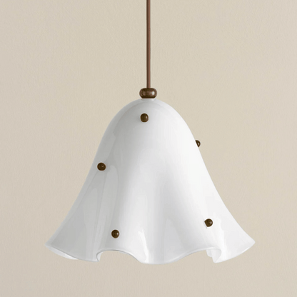 White pendant light with brass accents on a beige background
