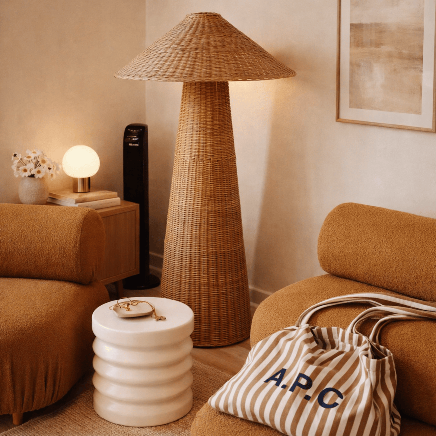 Living room with wicker floor lamp, striped bag, and brown sofa.