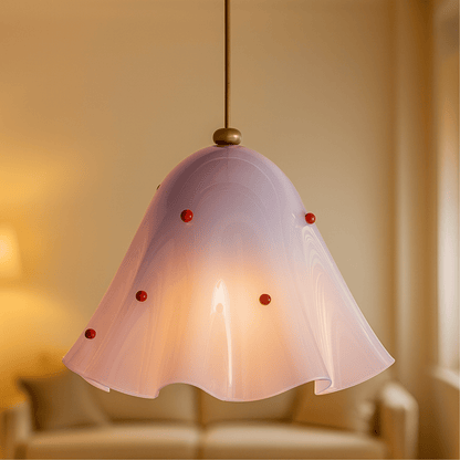Pink pendant light with red accents in a softly blurred room setting