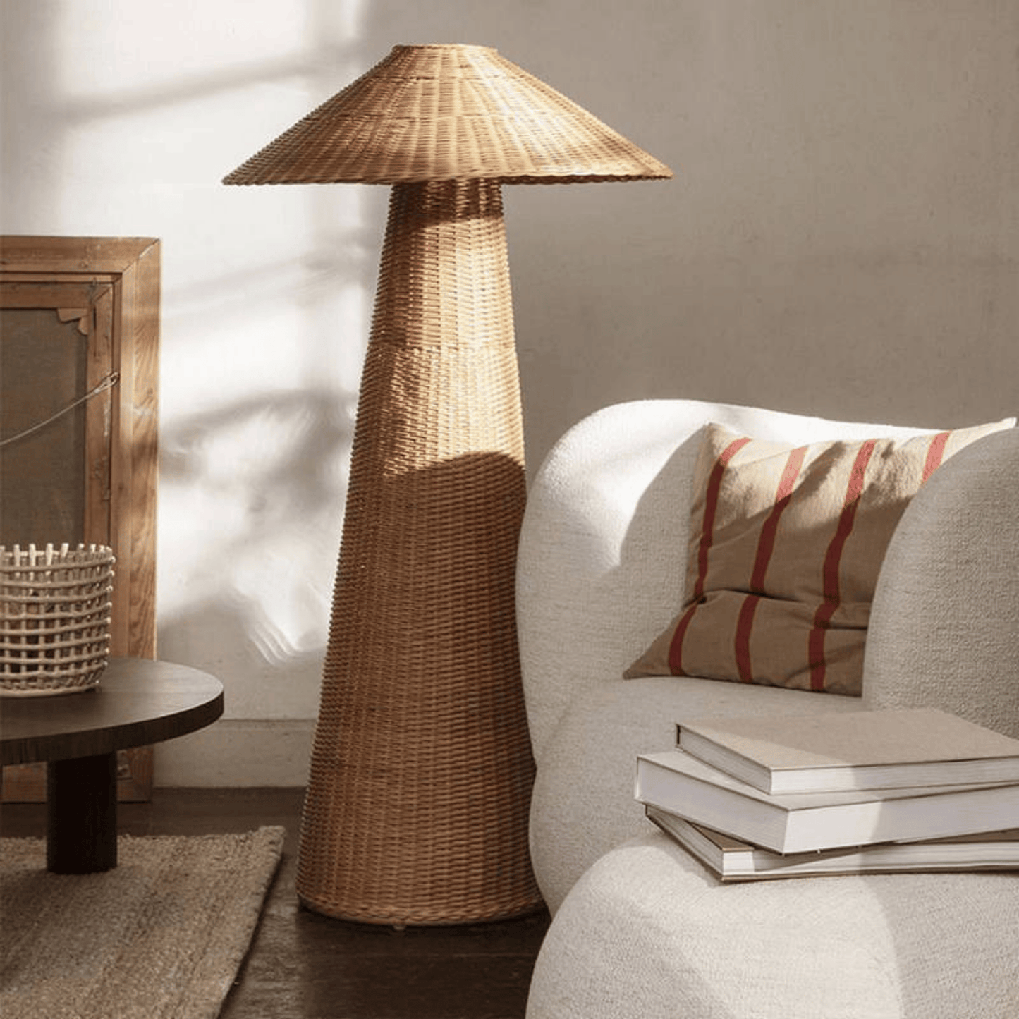 Wicker floor lamp in a living room setting with a sofa and books.