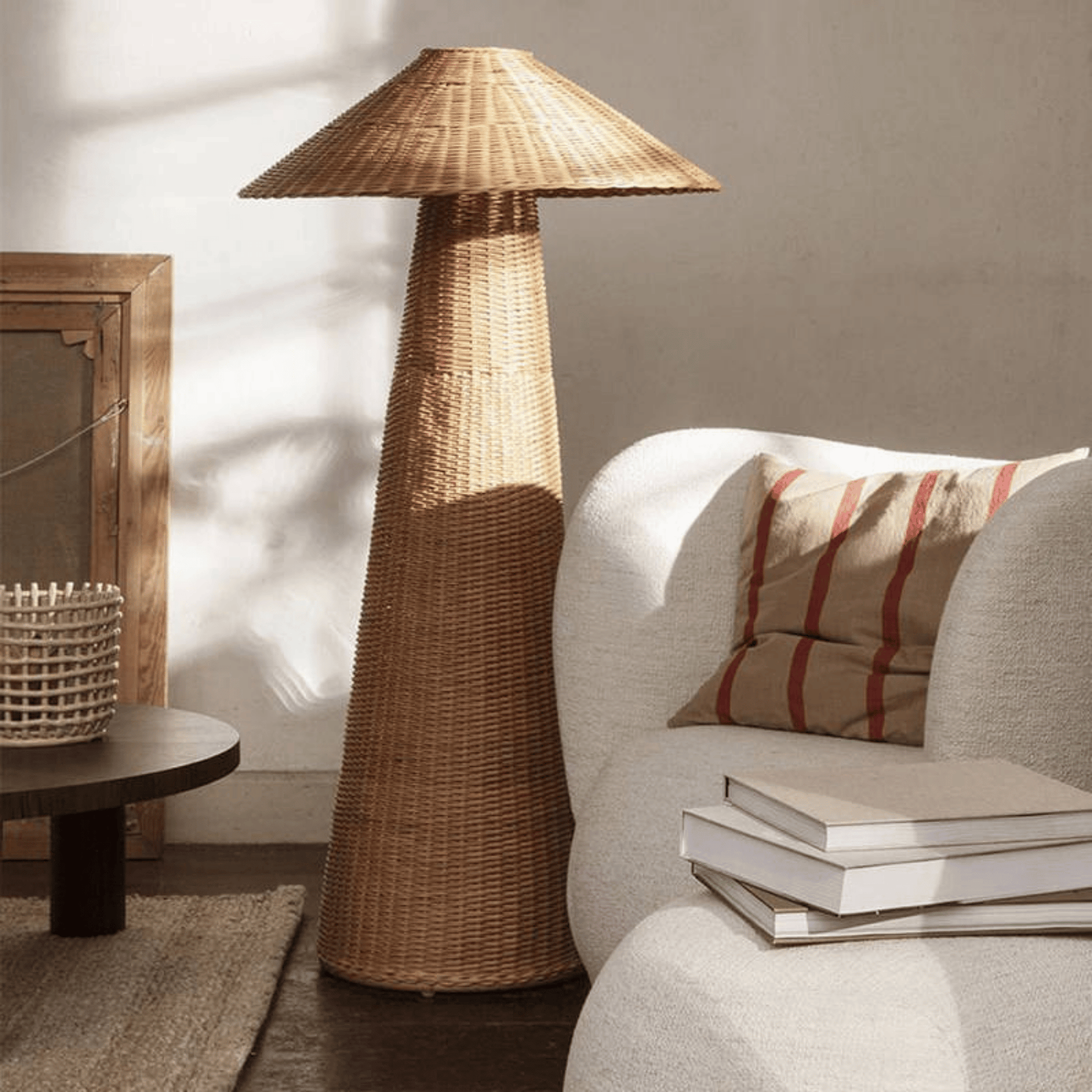 Wicker floor lamp in a living room setting with a sofa and books.