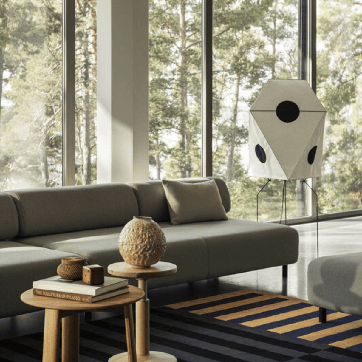 Modern living room with a gray sofa, wooden side table, and decorative items.