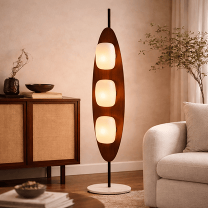 Wooden floor lamp with three light bulbs in a living room setting.