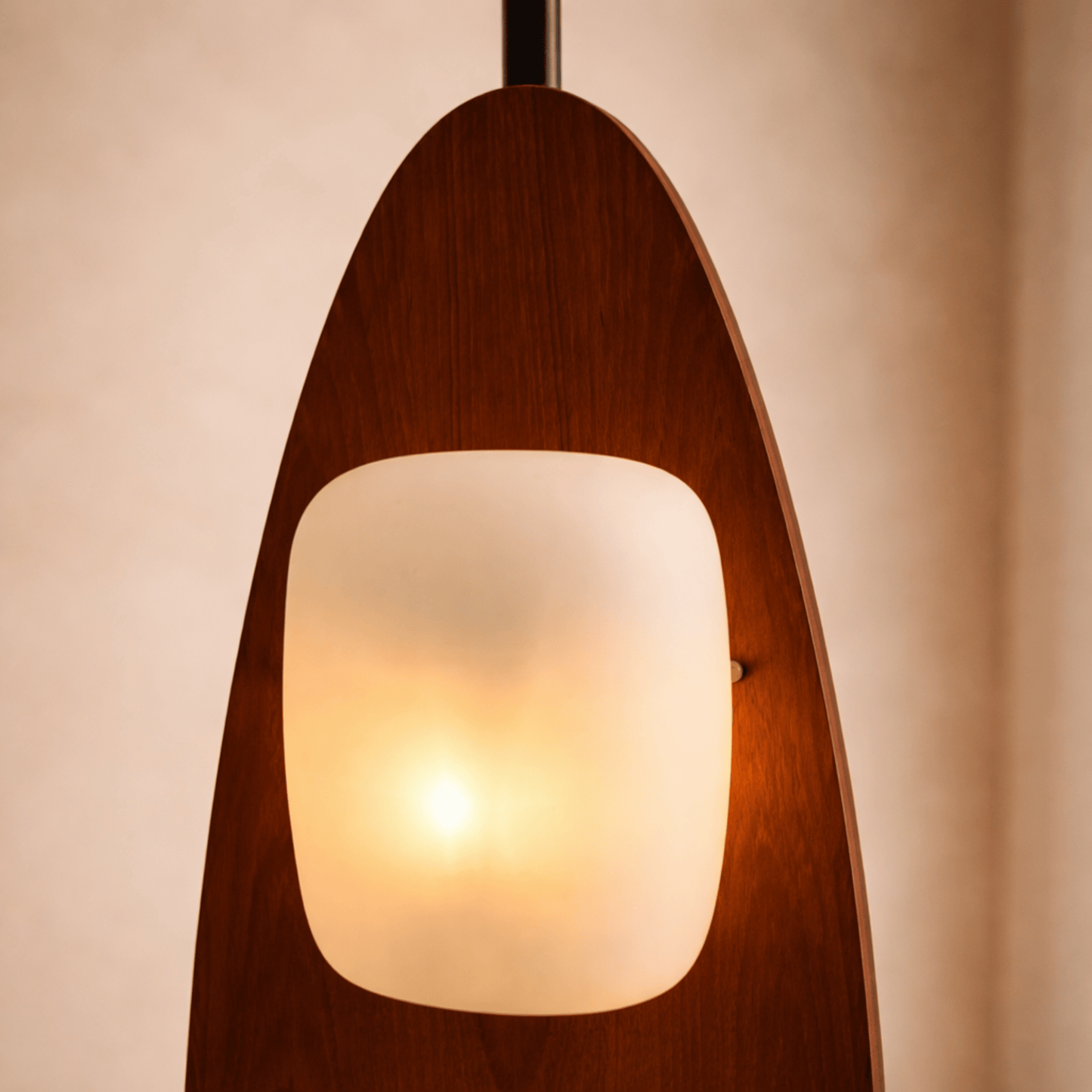 Wooden pendant light with a glass shade on a beige background