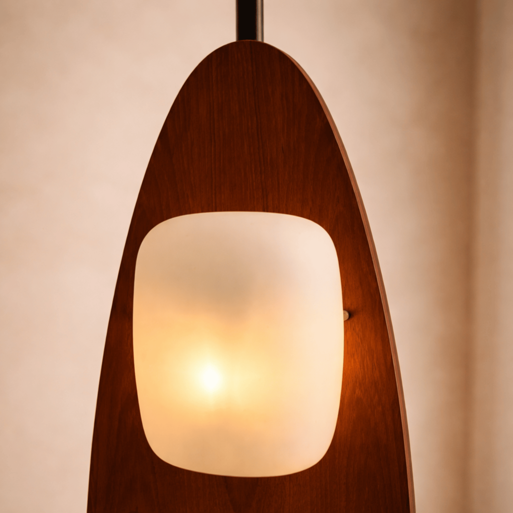 Wooden pendant light with a glass shade on a beige background