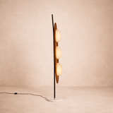 Modern floor lamp with multiple spherical lights on a beige background