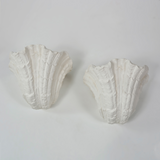 Two white decorative wall brackets on a light gray background