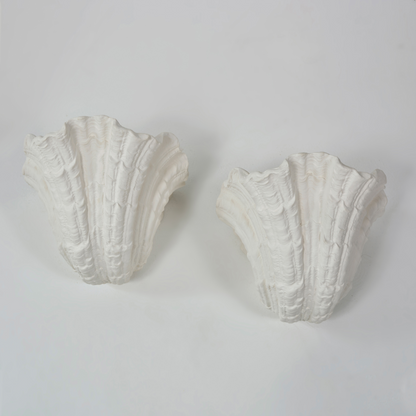 Two white decorative wall brackets on a light gray background