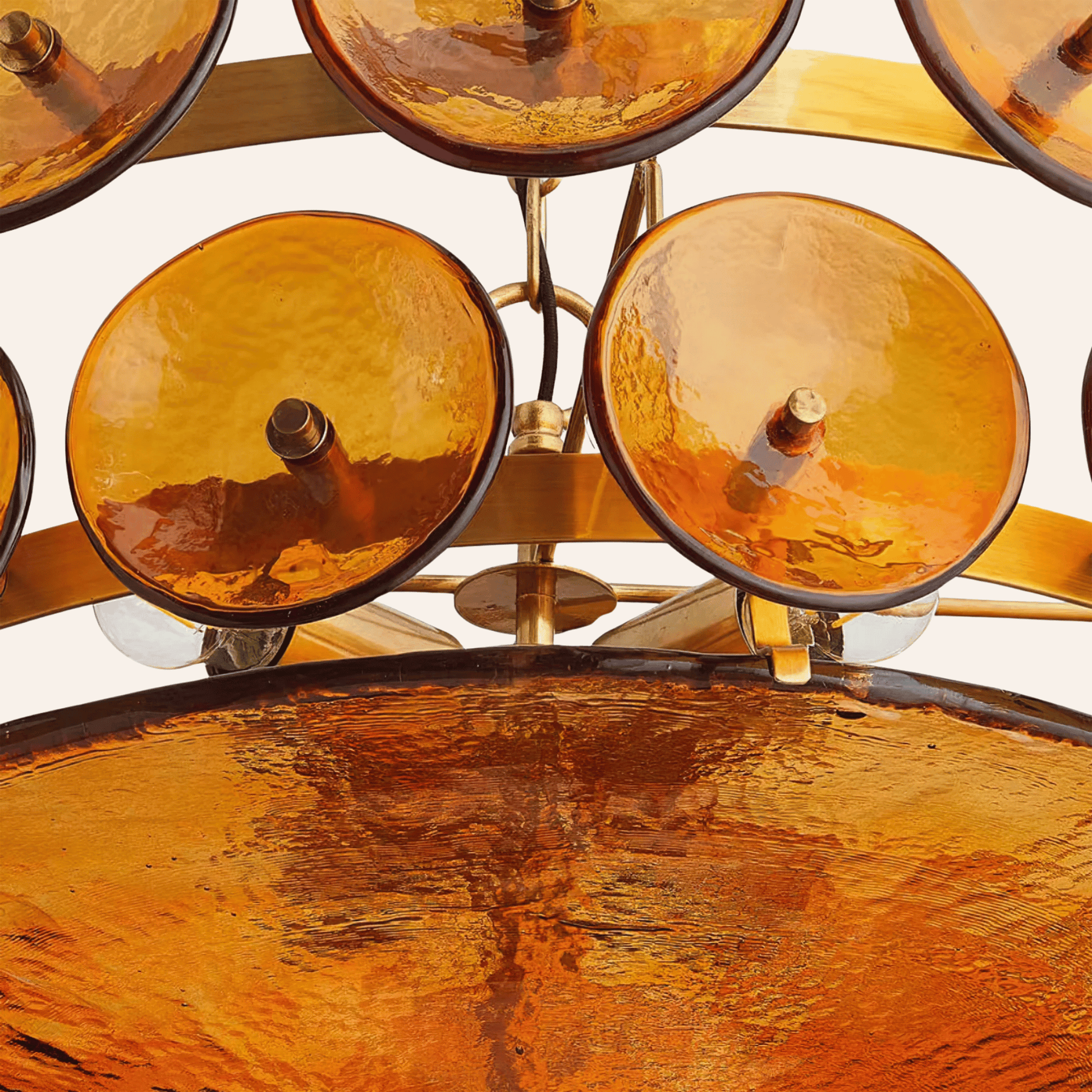 Close-up of a decorative object with amber-colored glass bowls and gold metalwork.