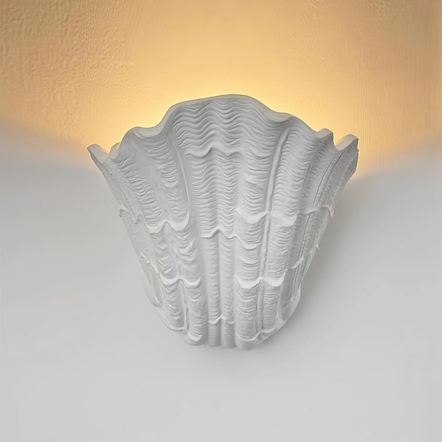 Decorative wall light with shell design on a white wall