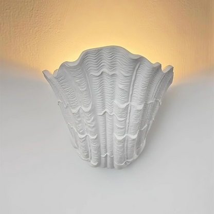 Decorative wall light with shell design on a white wall
