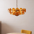 Gold chandelier with circular design on a neutral background