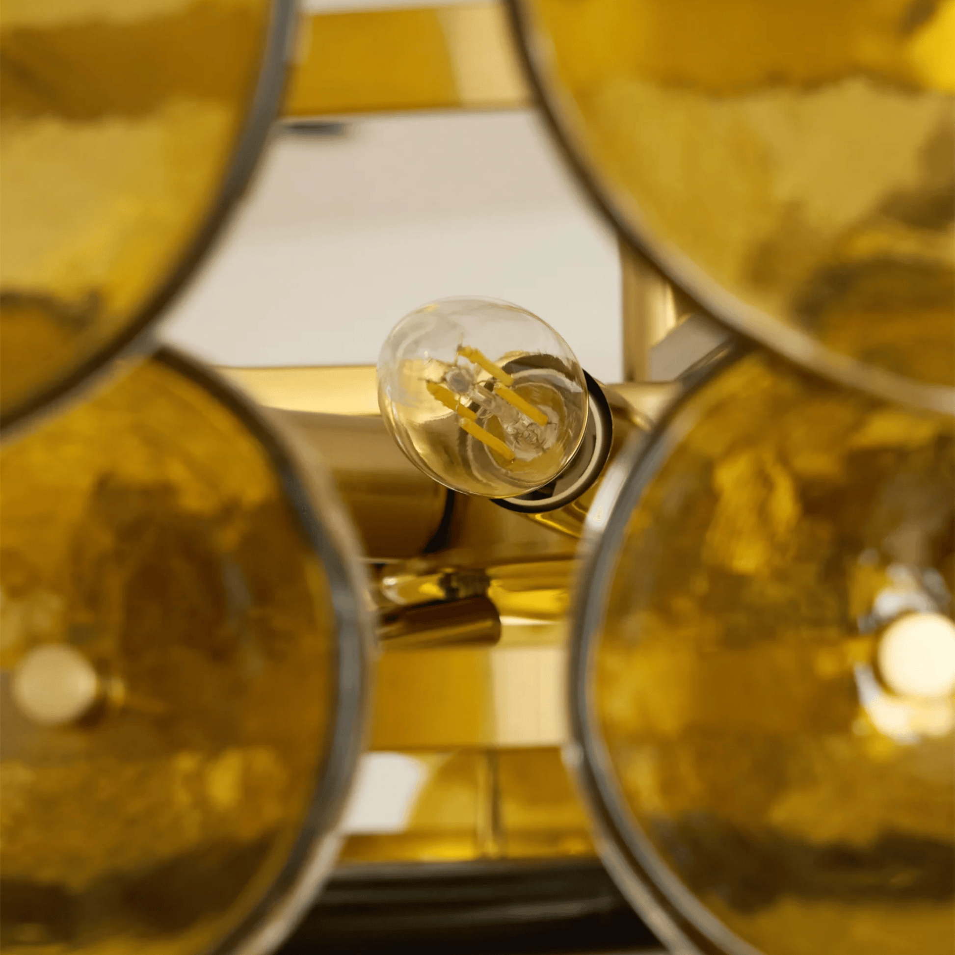 Close-up of a gold light fixture with a visible bulb