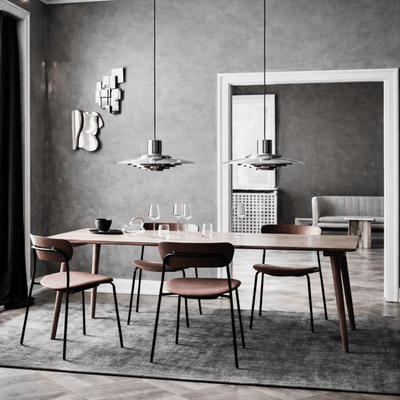 Modern dining room with wooden table and chairs against a gray wall.