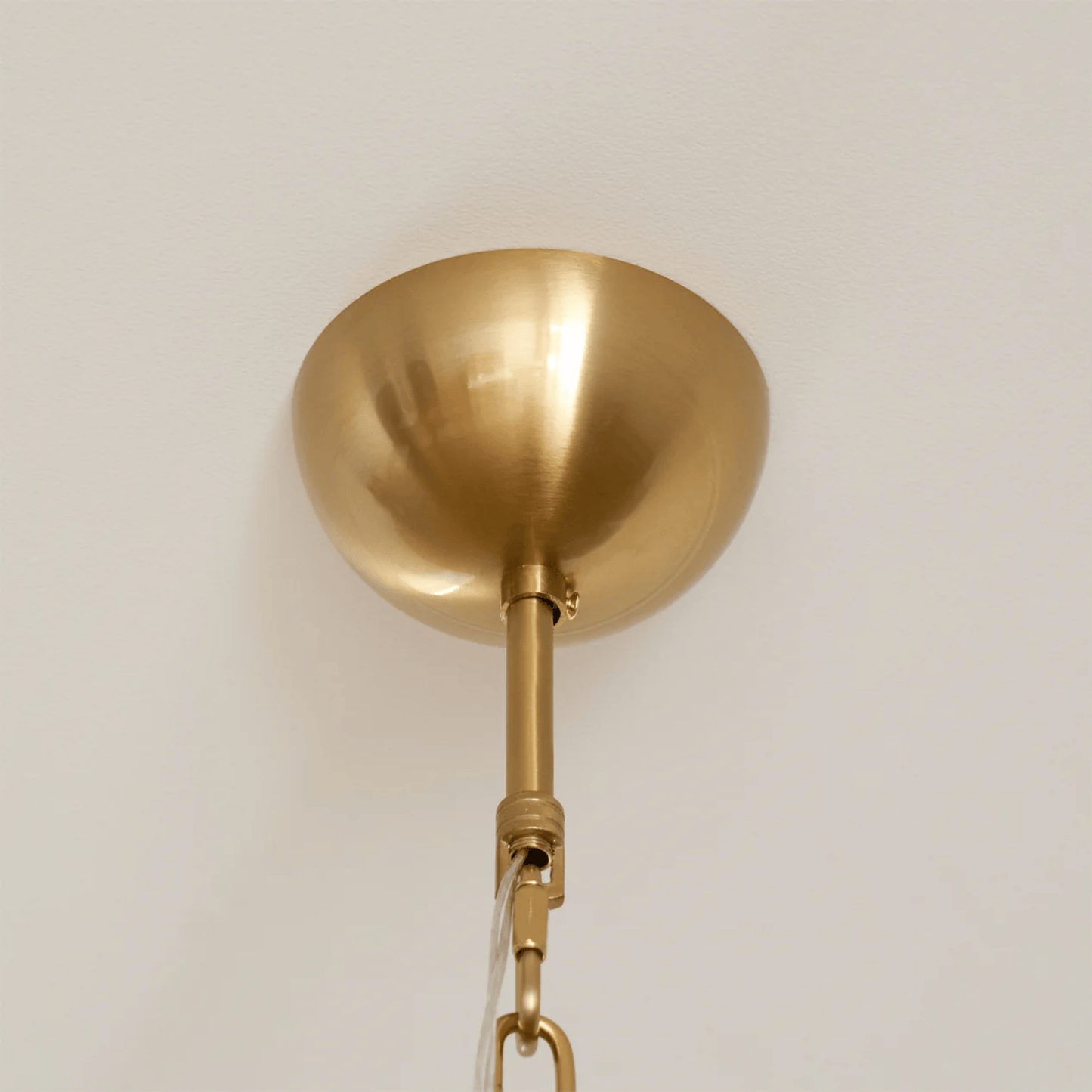 Gold pendant light fixture on a plain background