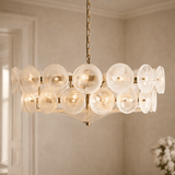 Chandelier with glass bubbles and gold frame in a room setting