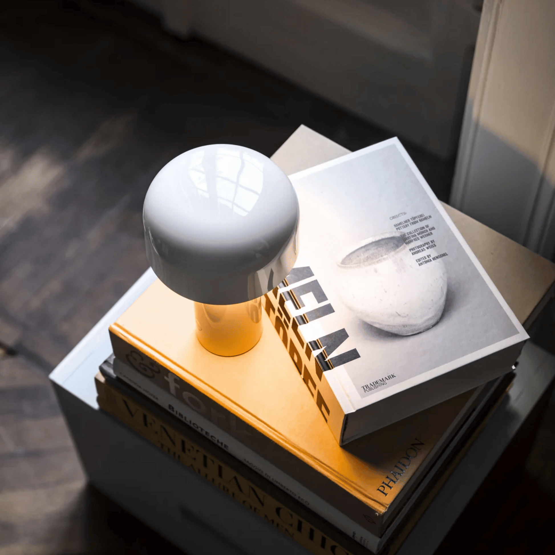 White spherical object on a yellow stand with a book underneath