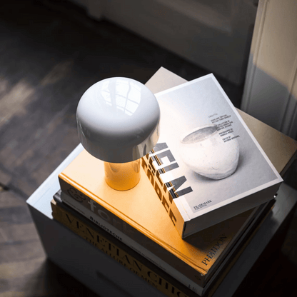 White spherical object on a yellow stand with a book underneath