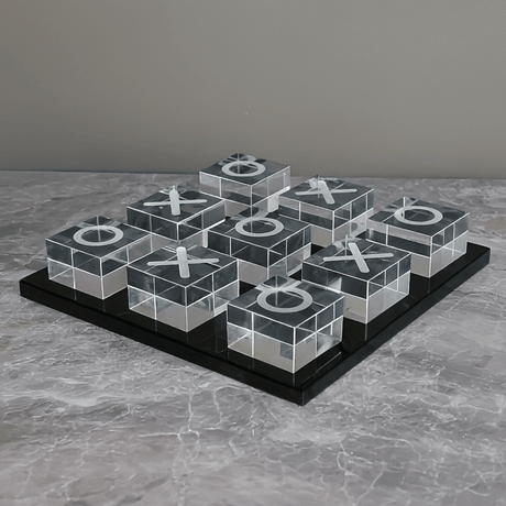Transparent tic-tac-toe board with Xs and Os on a gray surface