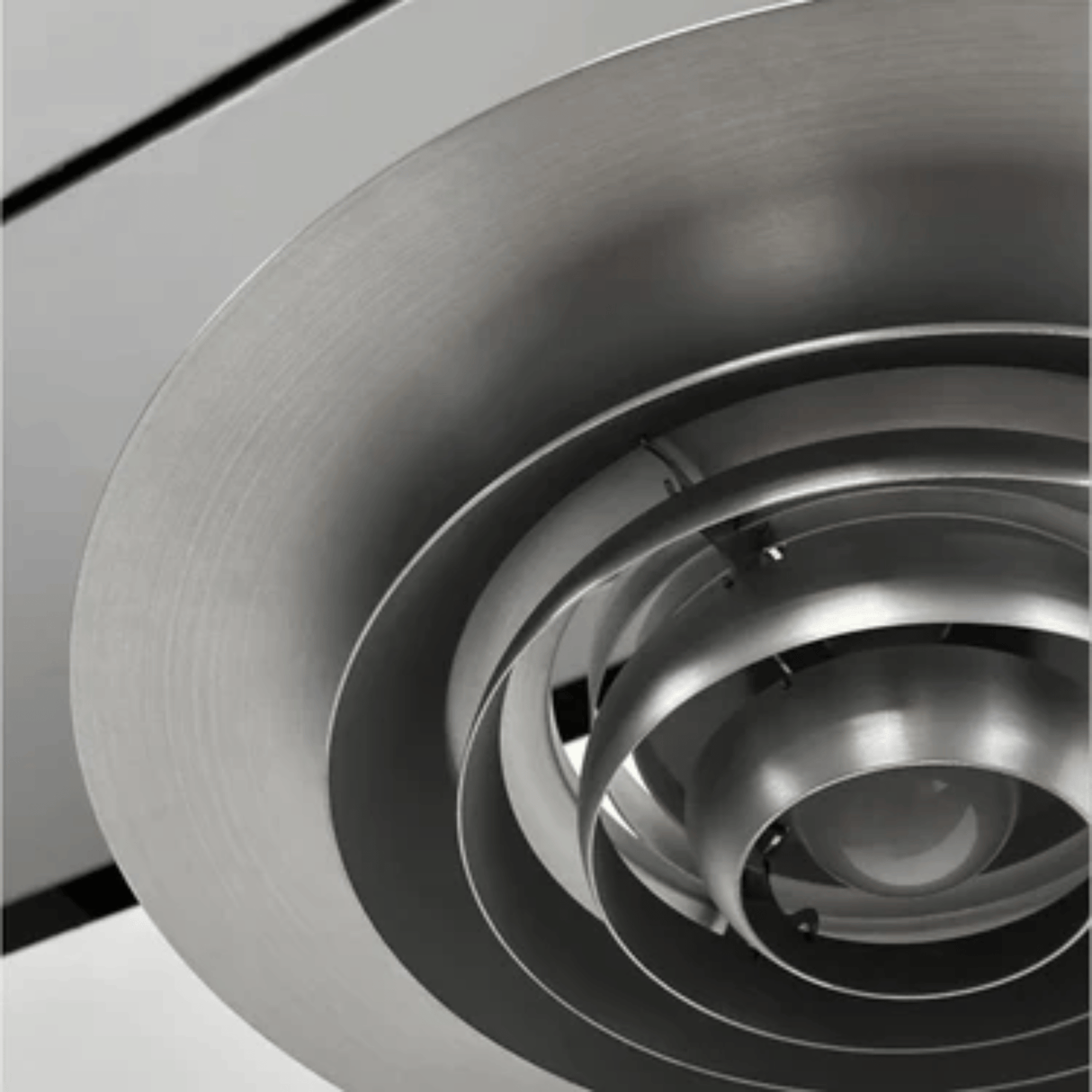 Close-up of a metallic ceiling vent with concentric circular design.