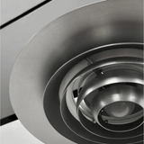 Close-up of a metallic ceiling vent with concentric circular design.