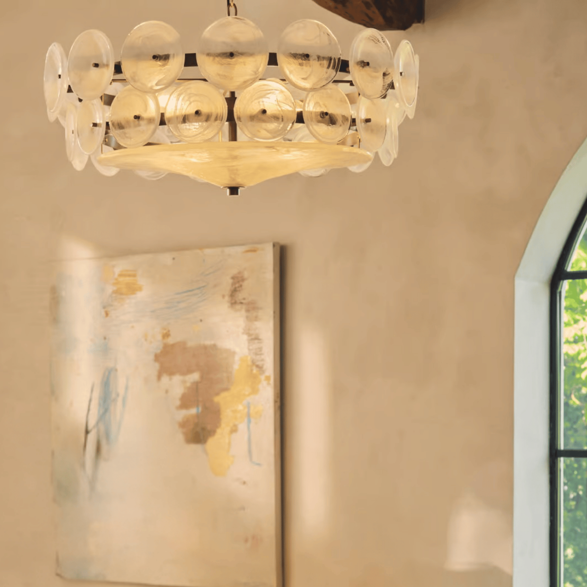 Chandelier hanging in a room with a painting and window