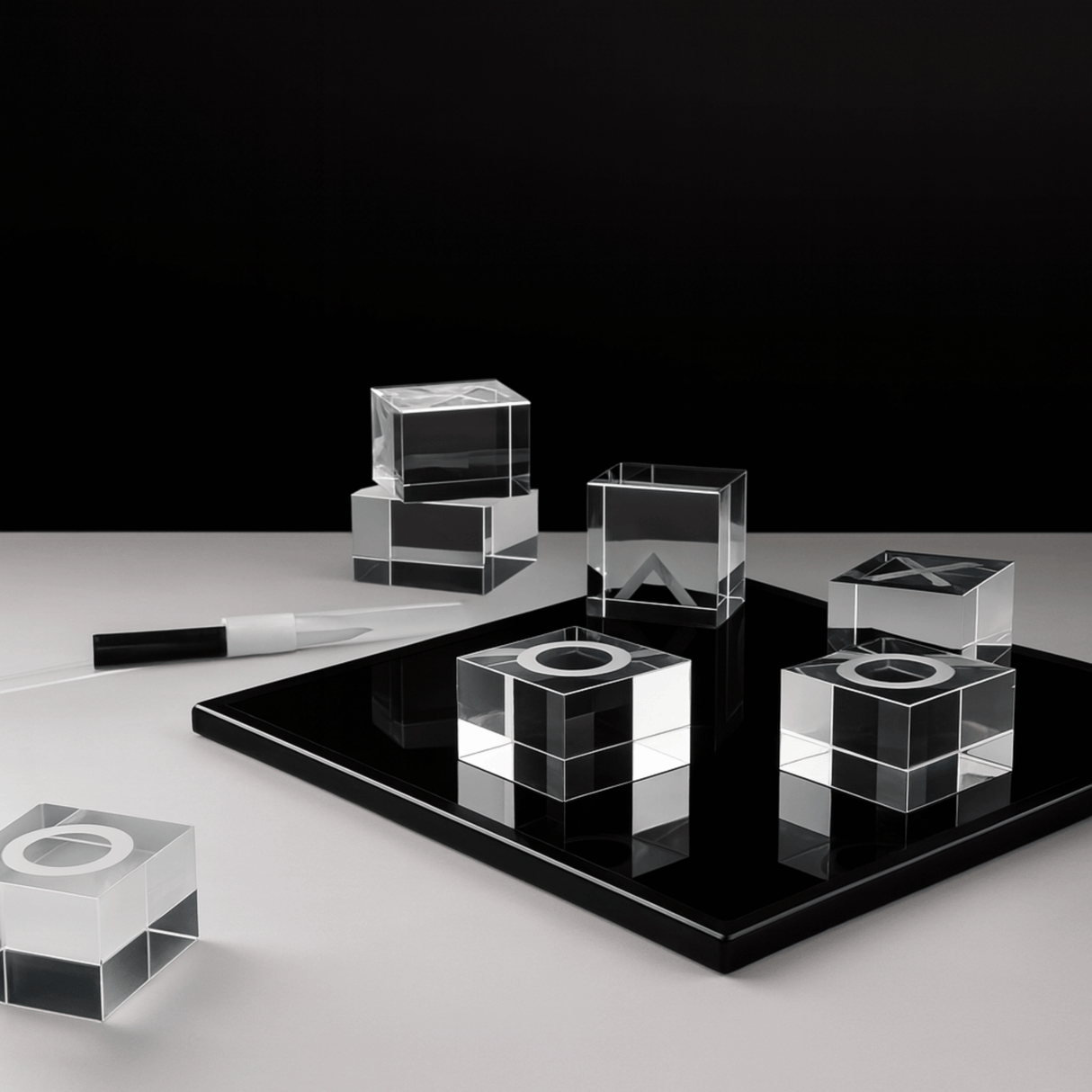 Set of clear glass cubes on a black platform with a white background