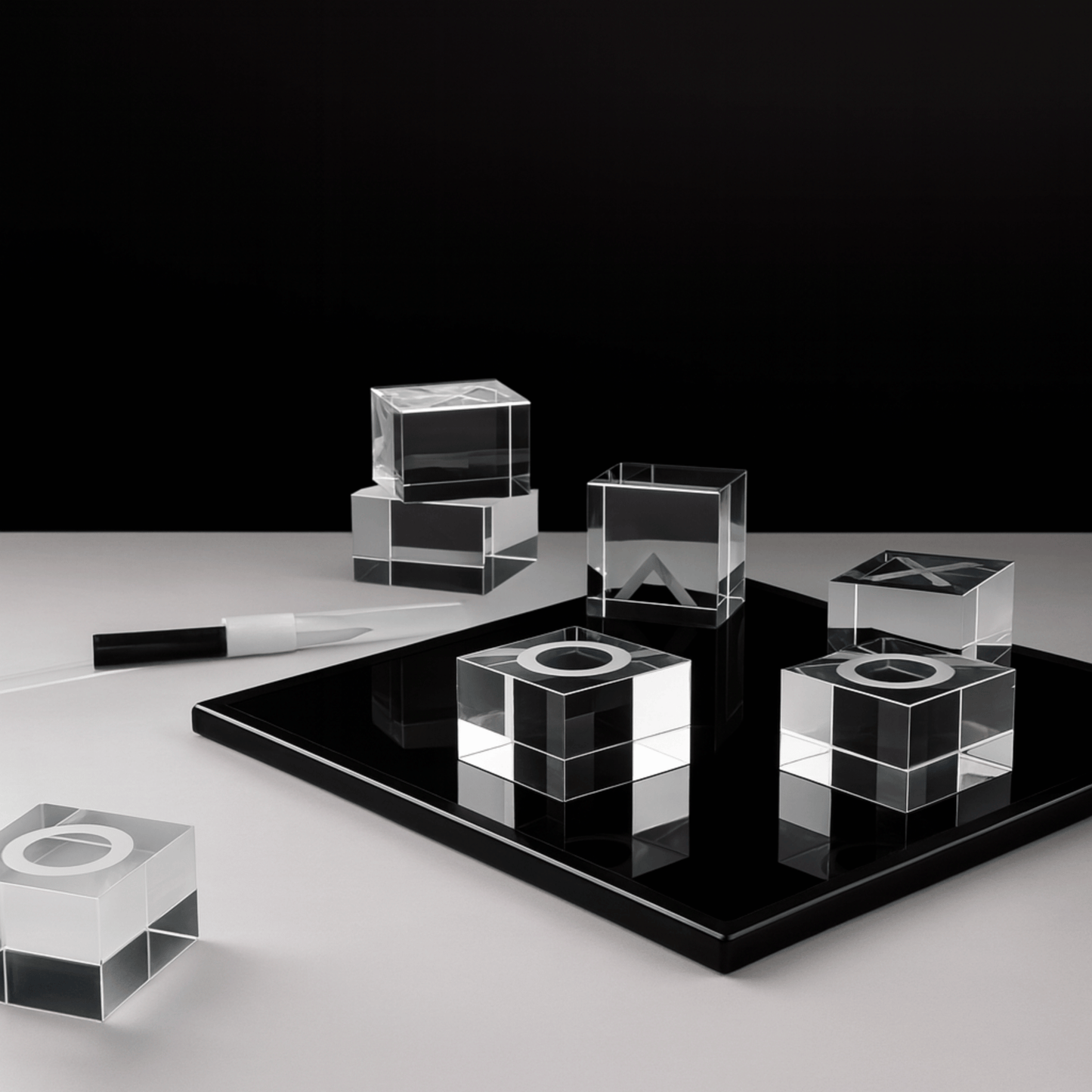 Set of clear glass cubes on a black platform with a white background