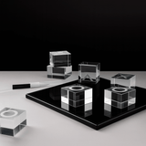 Set of clear glass cubes on a black platform with a white background
